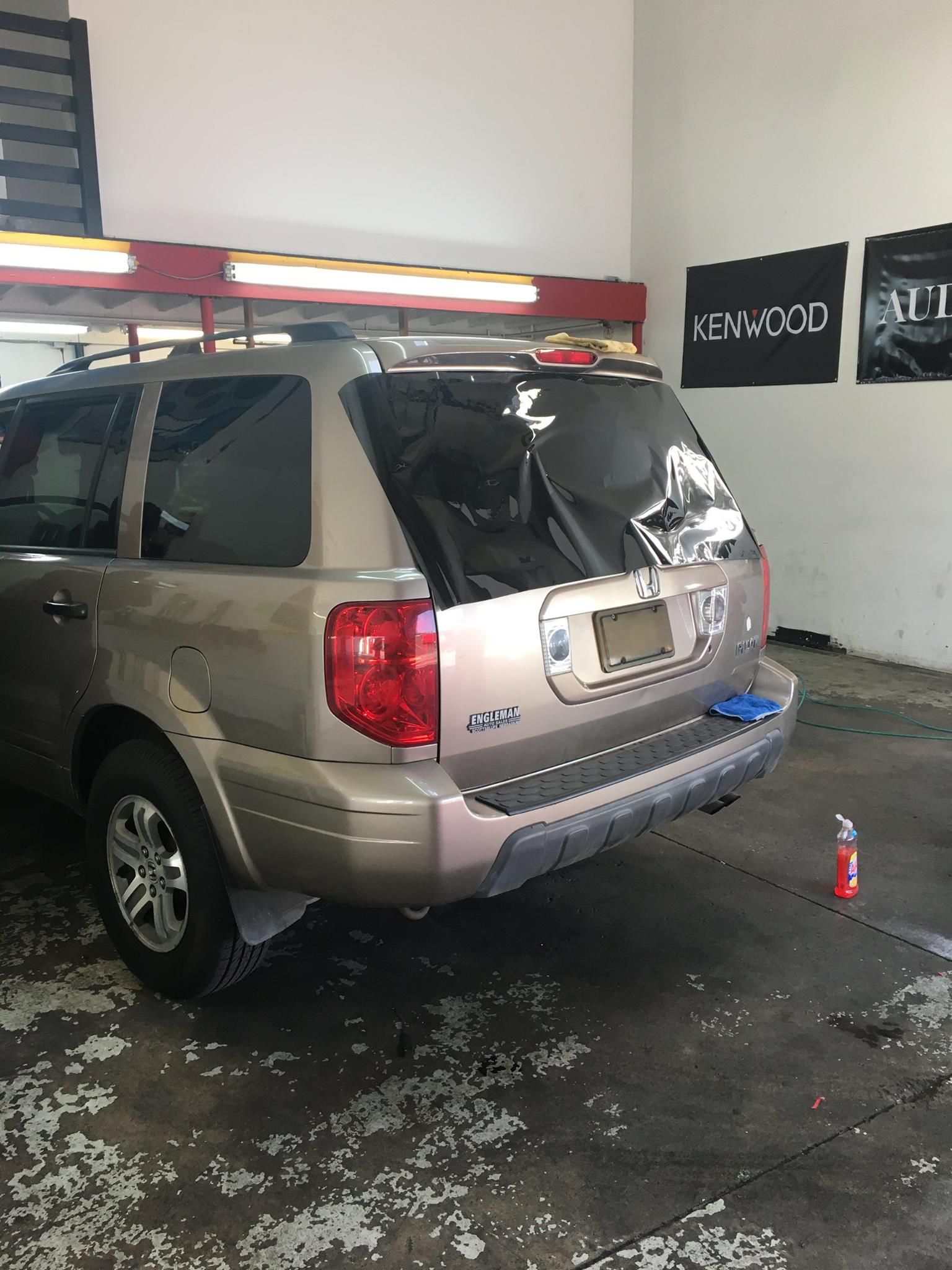 Tan SUV being worked on in a garage, tinted windows.