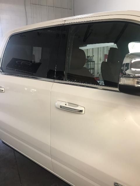 White pickup truck with tinted windows in a well-lit indoor setting.
