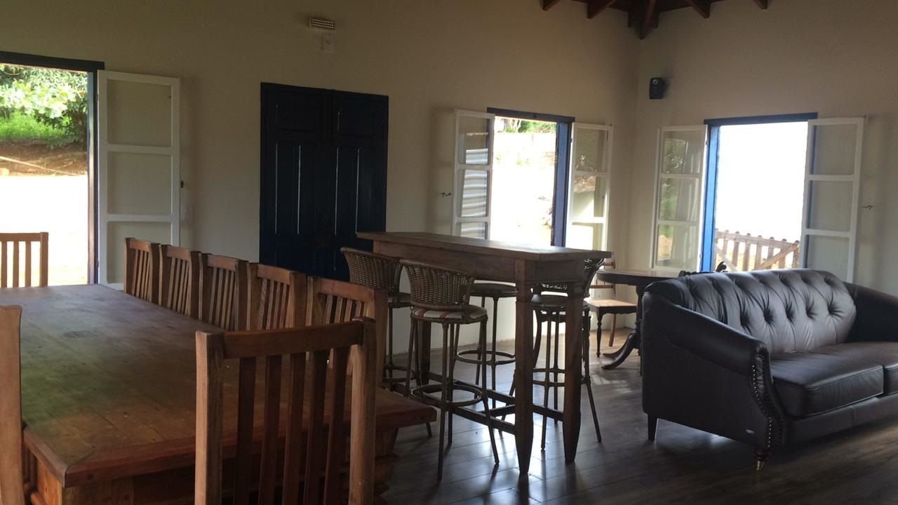 Sala ampla com móveis e portas de madeira, luz natural e uma porta azul escura.