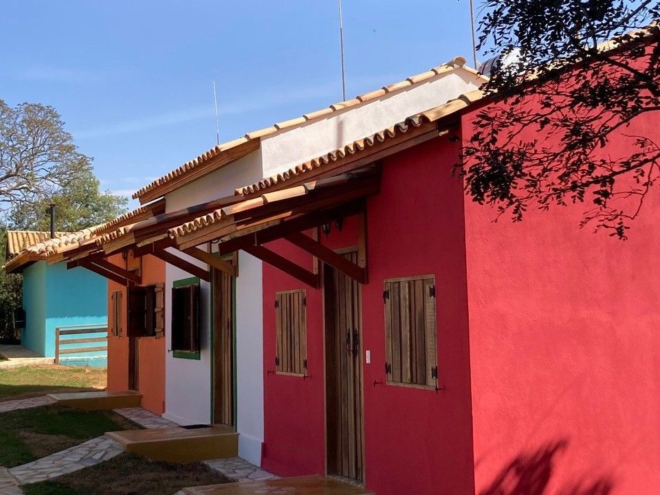 Fileira de casinhas coloridas com detalhes em madeira, tendo como pano de fundo um céu azul.