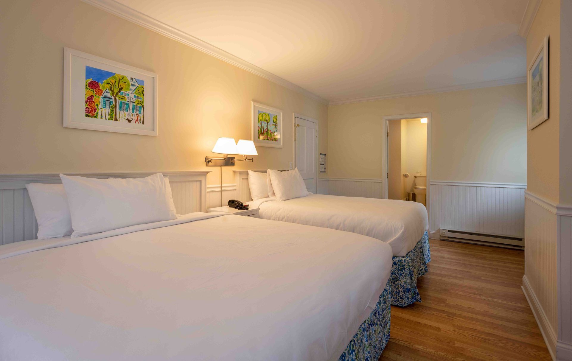 A hotel room with two beds and a bathroom.