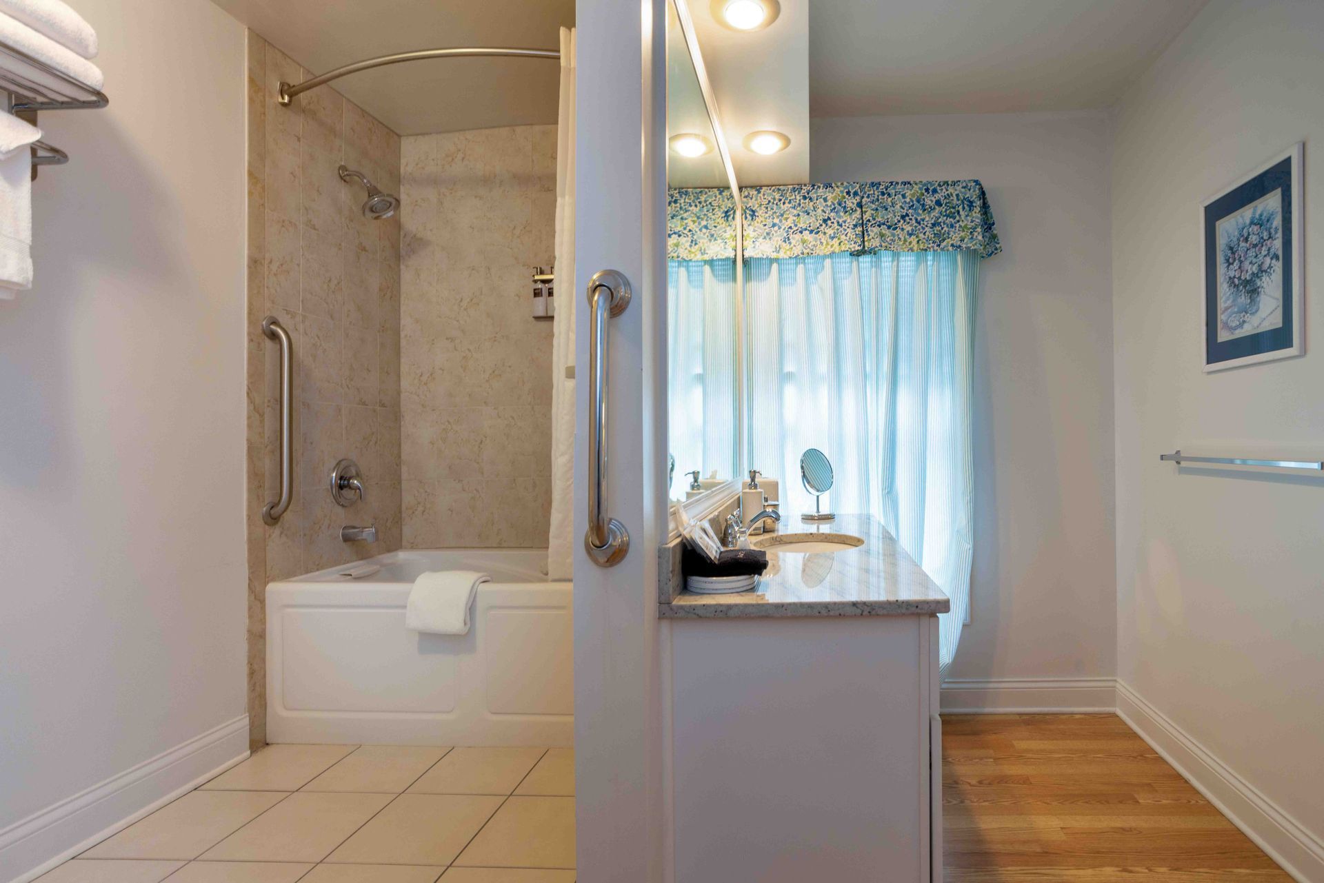A bathroom with a tub , sink and mirror.