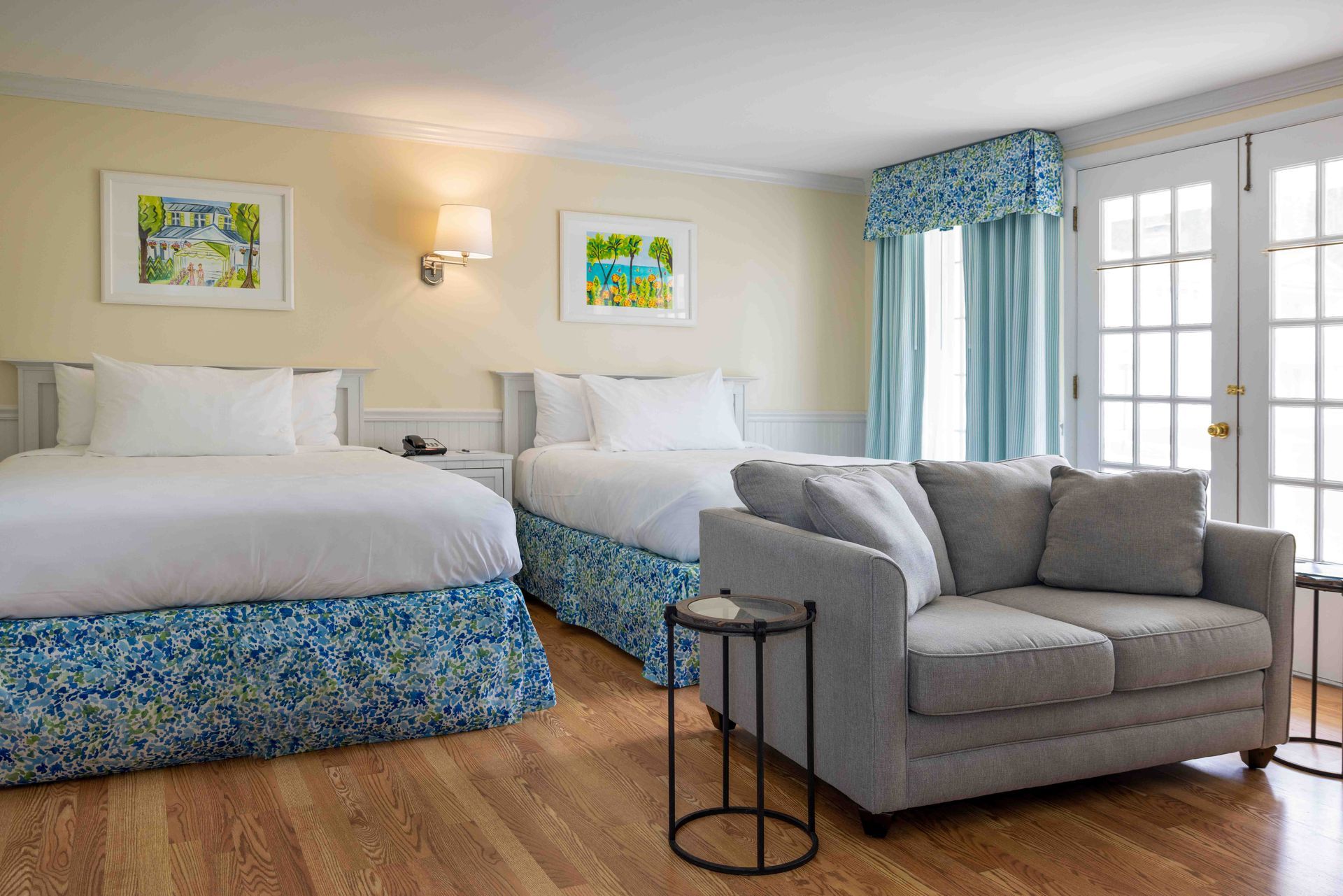 A hotel room with two beds , a couch , and a table.