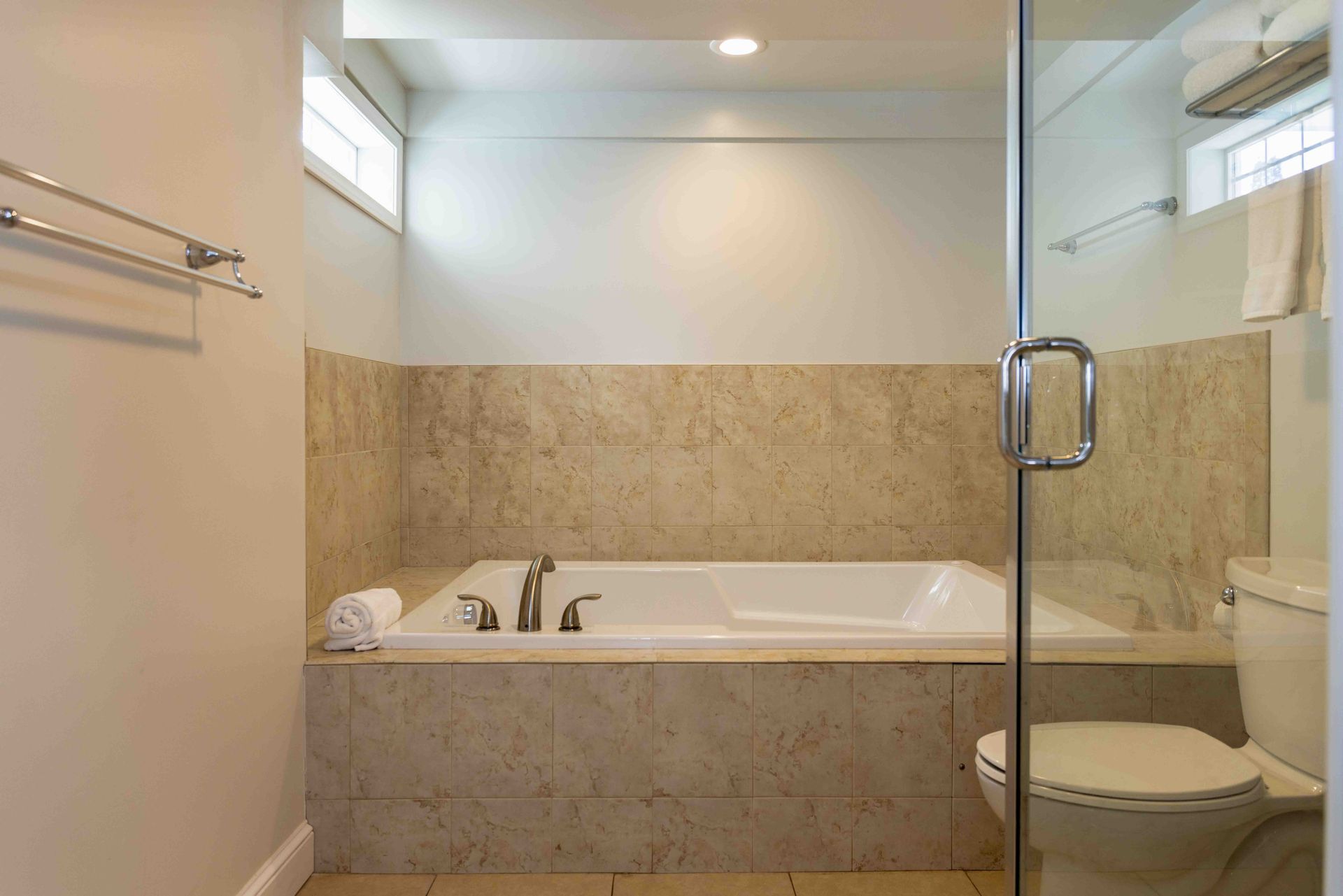 A bathroom with a tub , toilet and shower.