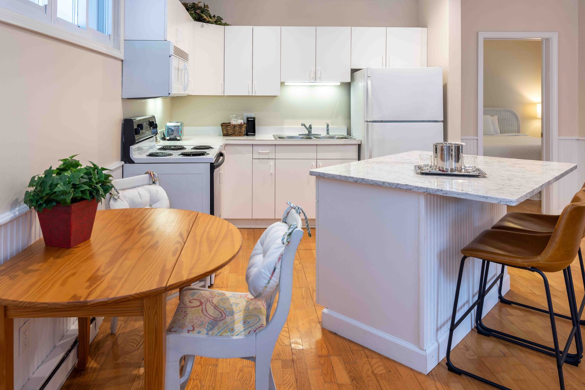 A kitchen with a table and chairs and a refrigerator.