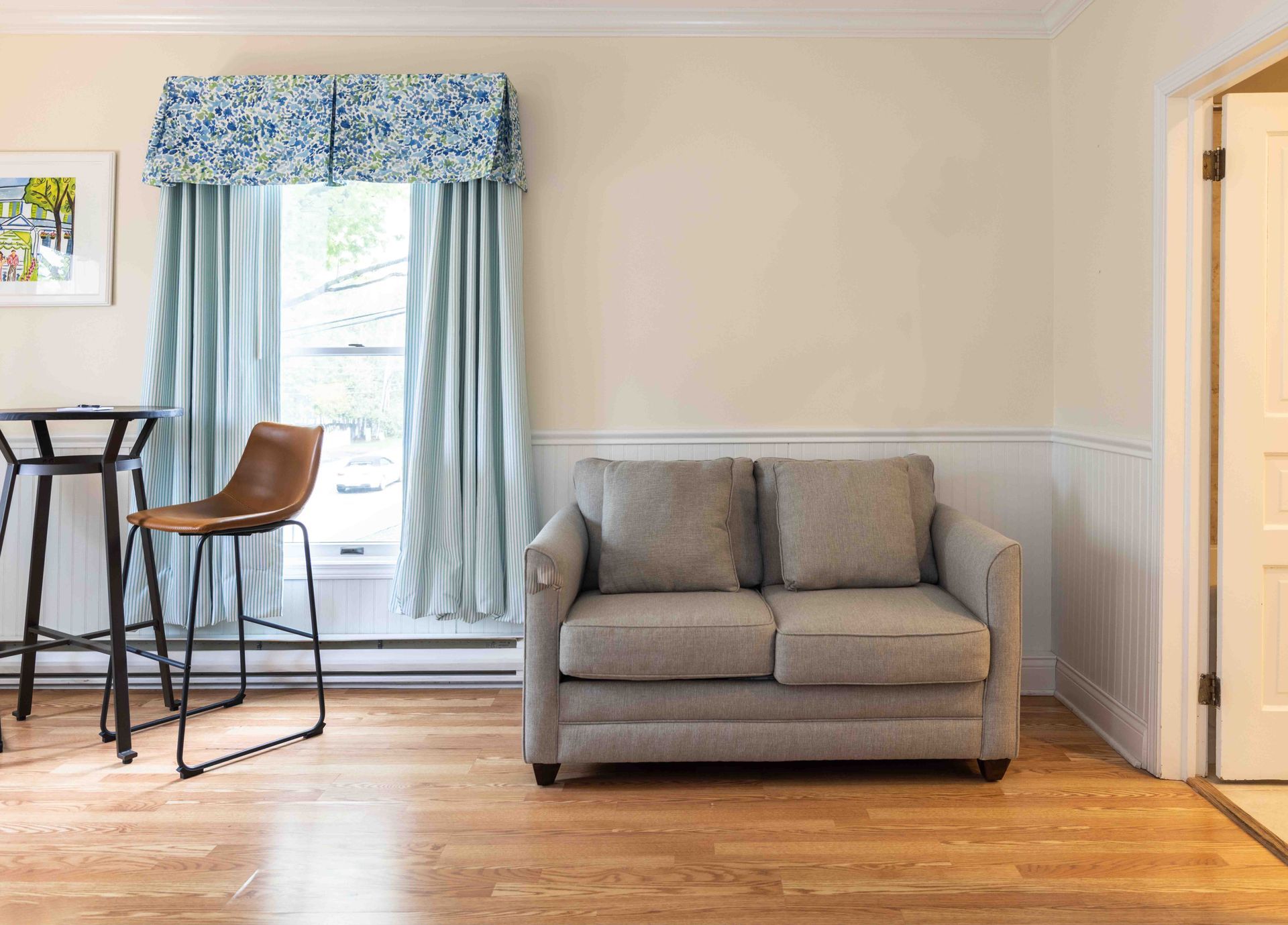 A living room with a couch , table and chairs.