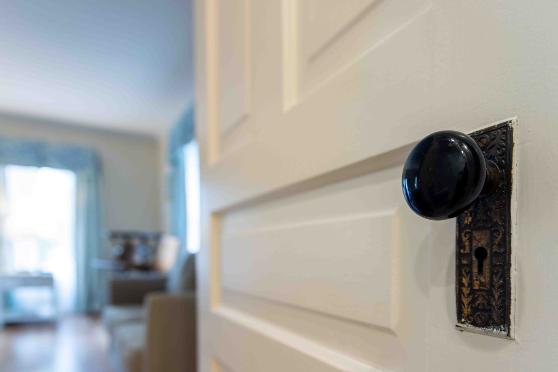 A close up of a door with a black door knob in a living room.