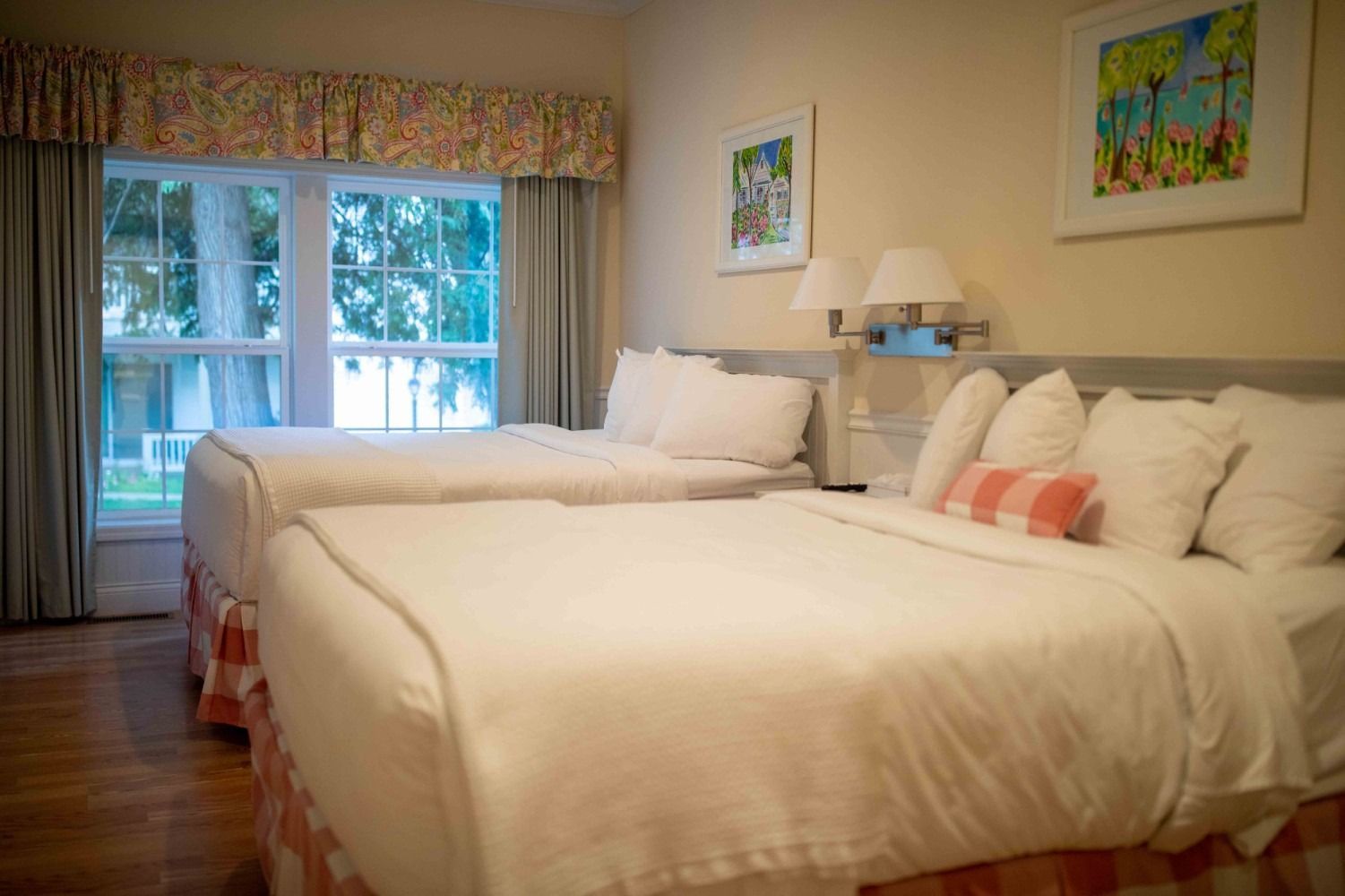 A hotel room with two beds and a large window.