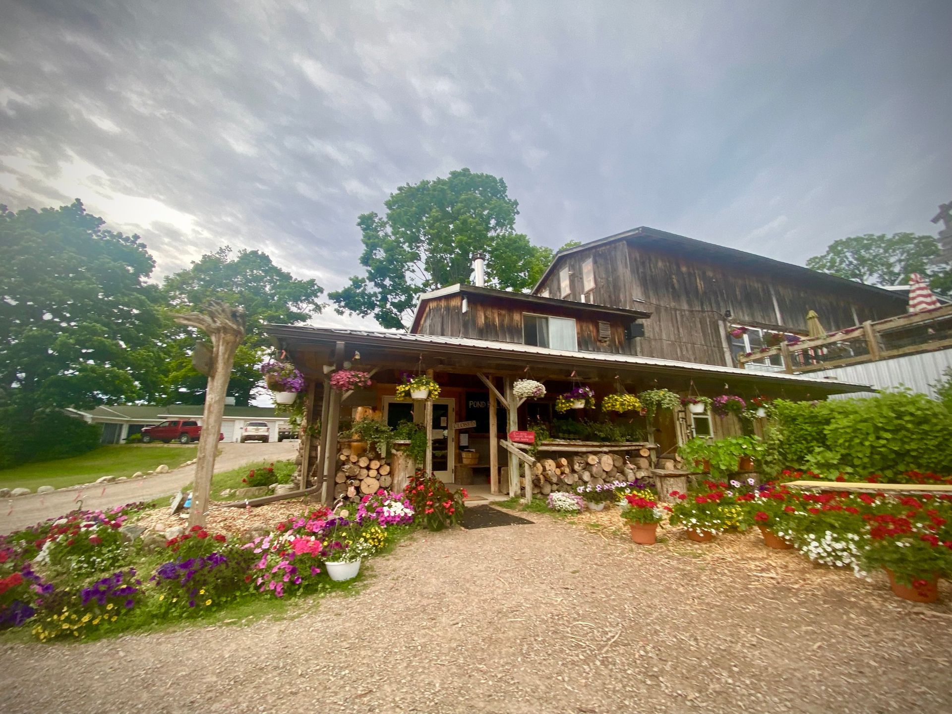 A large wooden building with a lot of flowers in front of it.