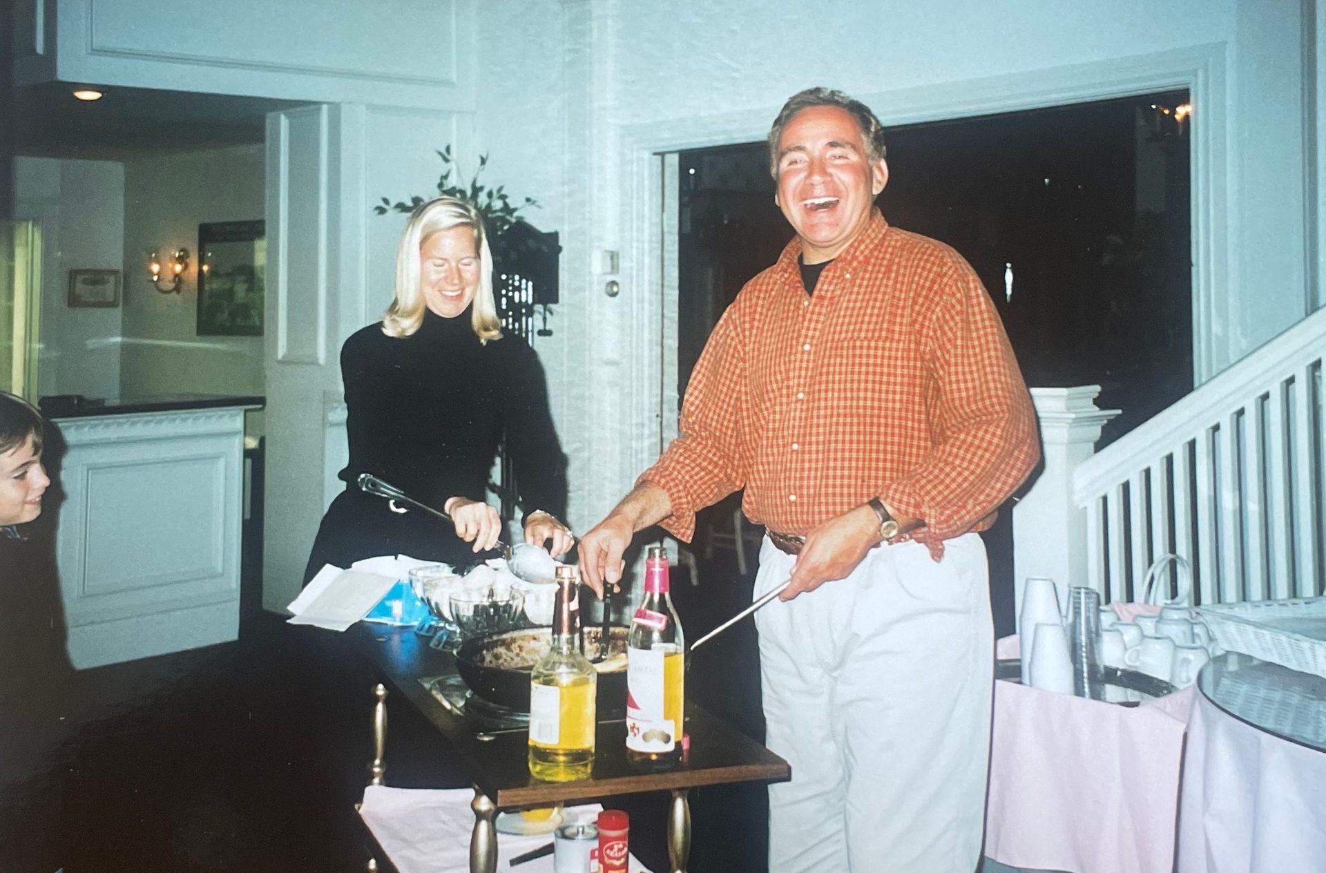 A man and a woman standing next to a table with bottles on it