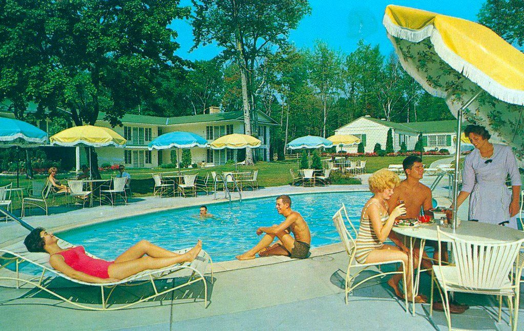 A group of people are sitting around a swimming pool