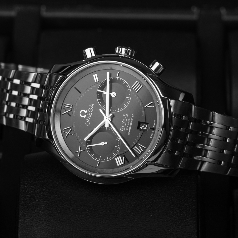 Silver chronograph wristwatch with a white face and three sub-dials, set against a white background.