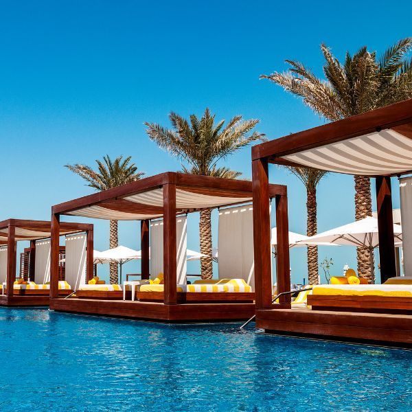 A row of canopies sit next to a swimming pool