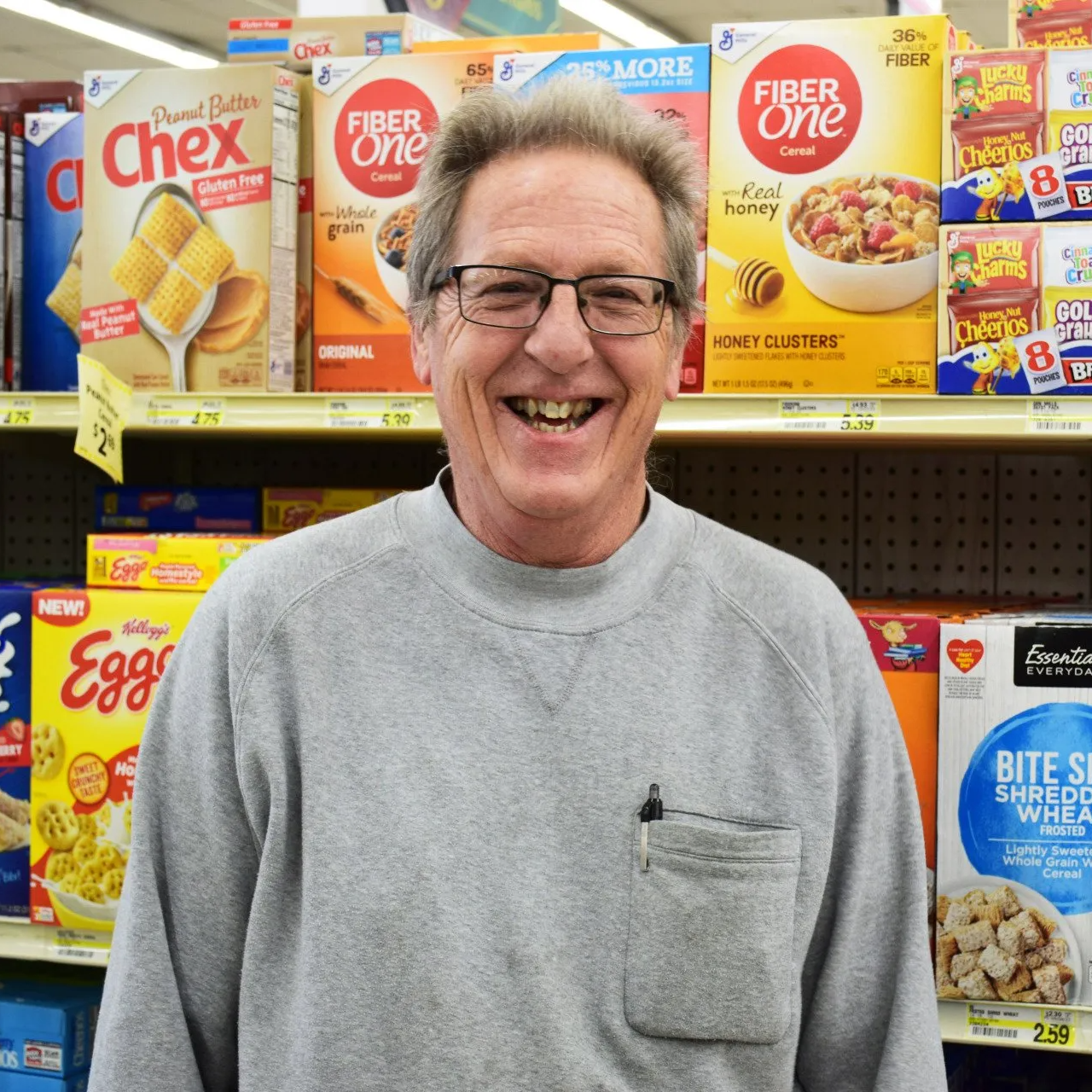 A man standing in front of a shelf full of cereal boxes including fiber one