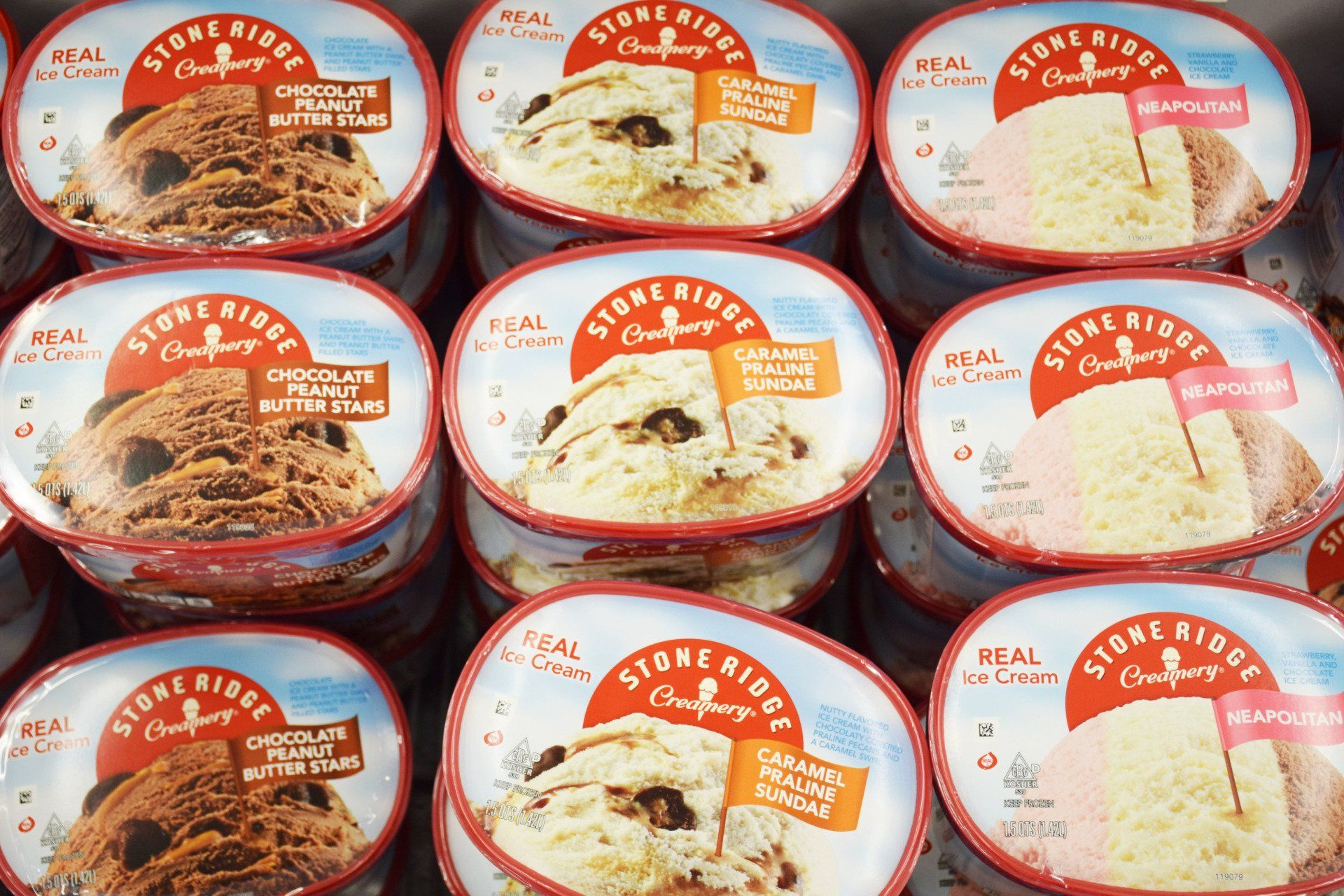 Several containers of stone ridge ice cream are stacked on top of each other