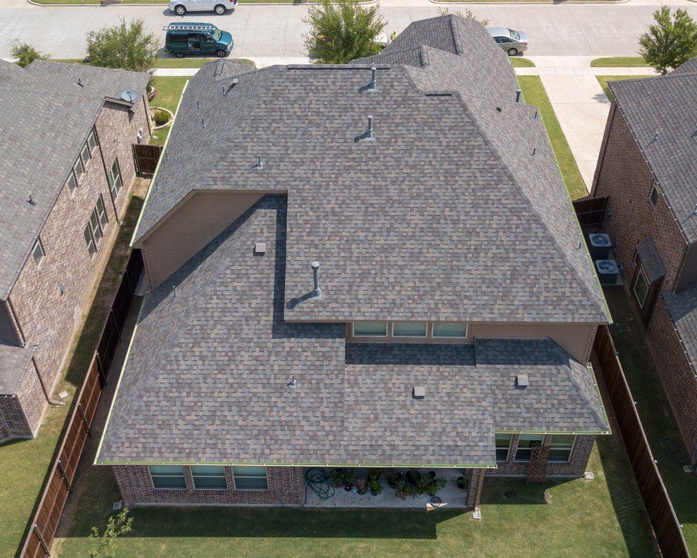 an aerial view of a house with a gray roof