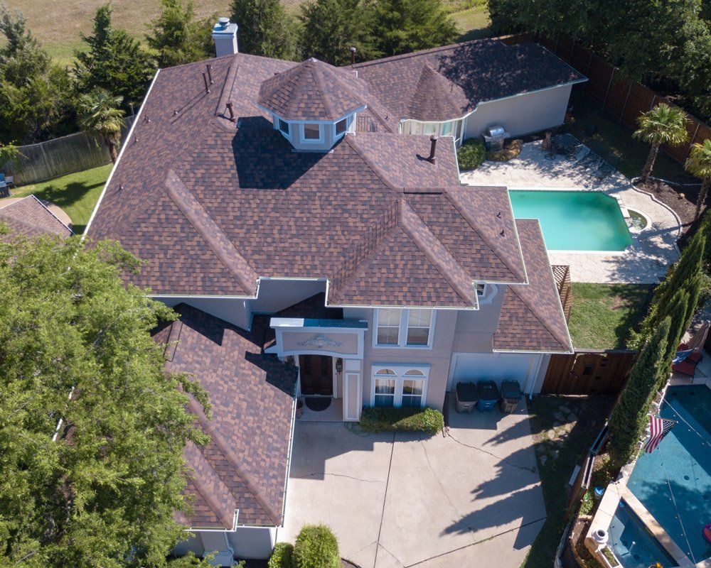 an aerial view of a large house with a pool in the backyard