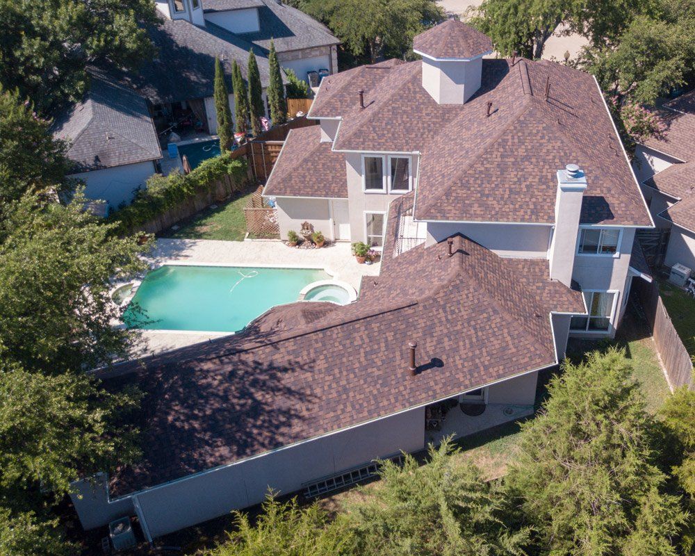 an aerial view of a house with a large pool