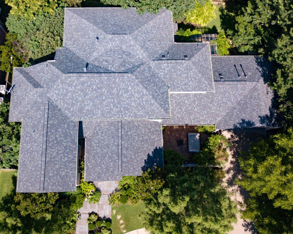 an aerial view of a large house with a gray roof