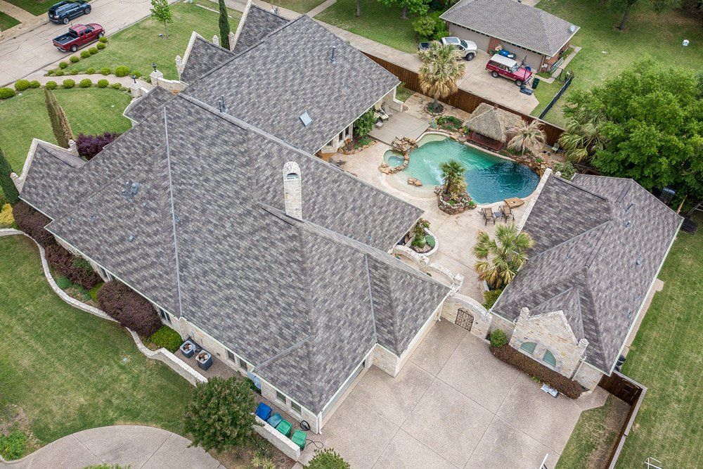 an aerial view of a large house with a pool