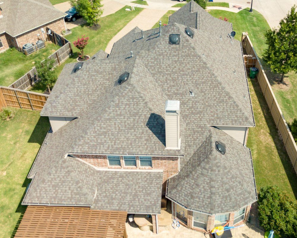 an aerial view of a large house with a gray roof