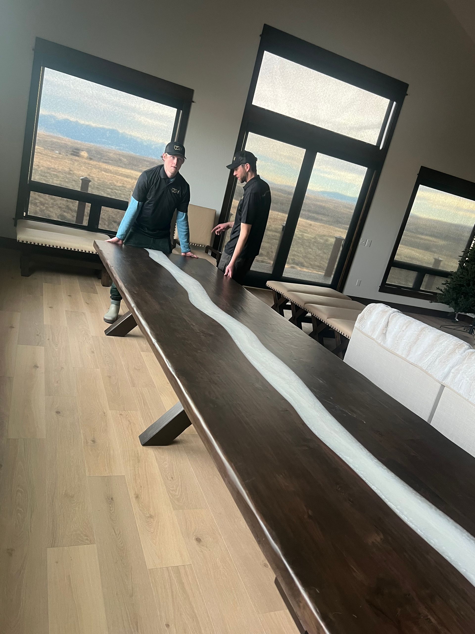 Two men are standing next to a long wooden table