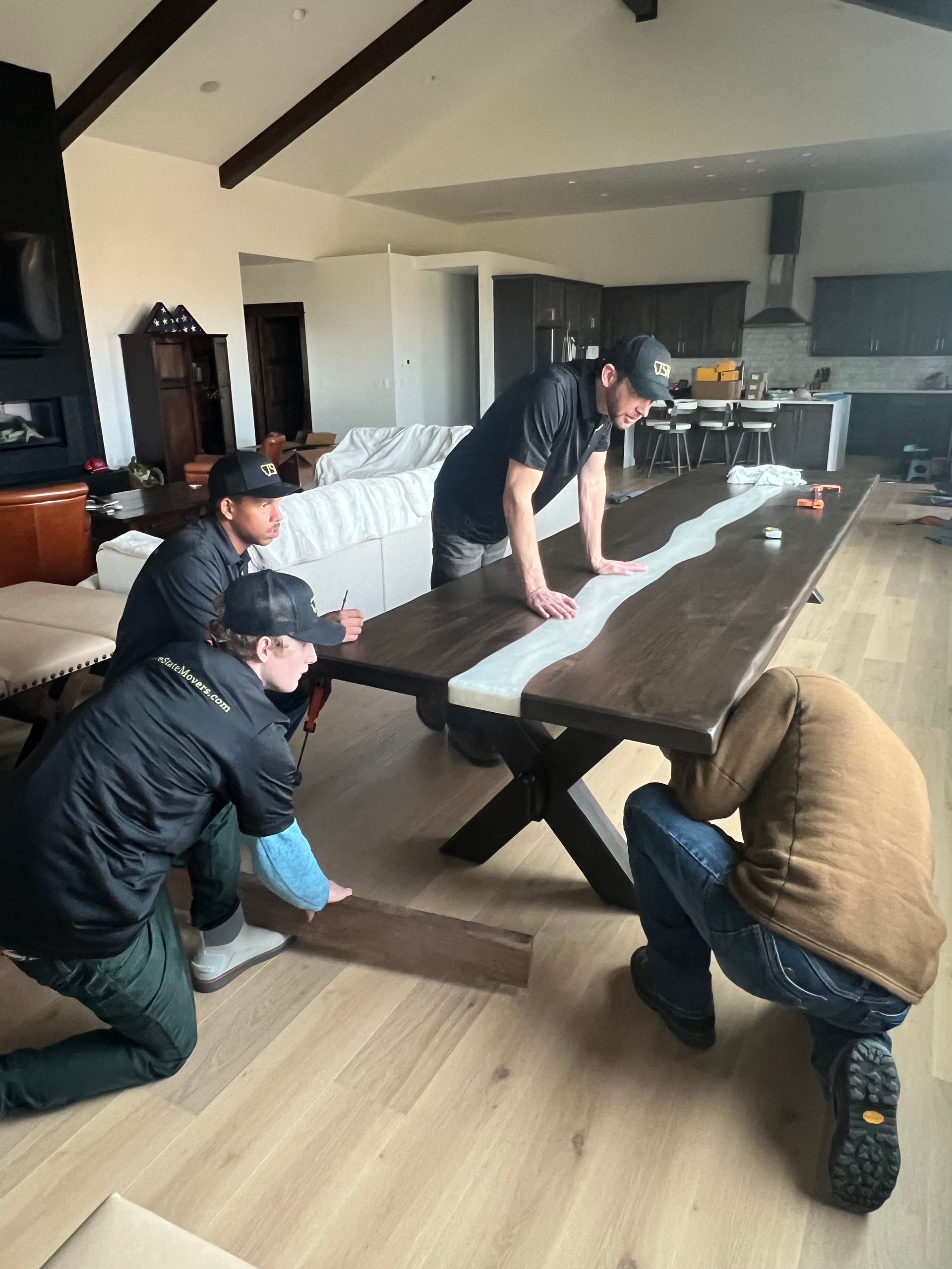 A group of men are working on a table in a living room