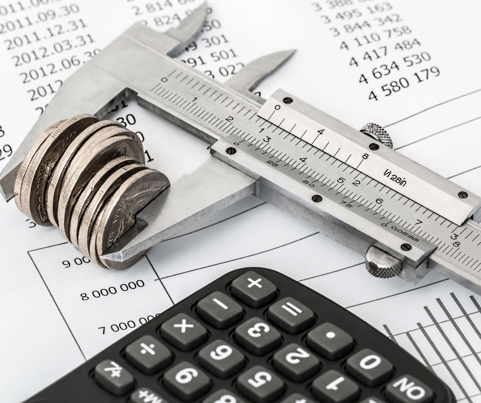 Coins being measured with calipers, a calculator, and financial data in the background. Coins being measured with calipers, a calculator, and financial data in the background.