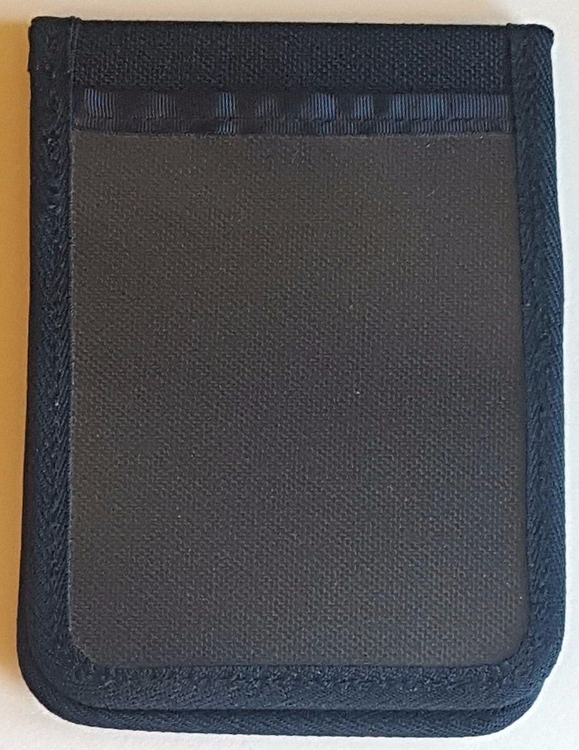 A black Duty Notebook cover sitting on a white table.