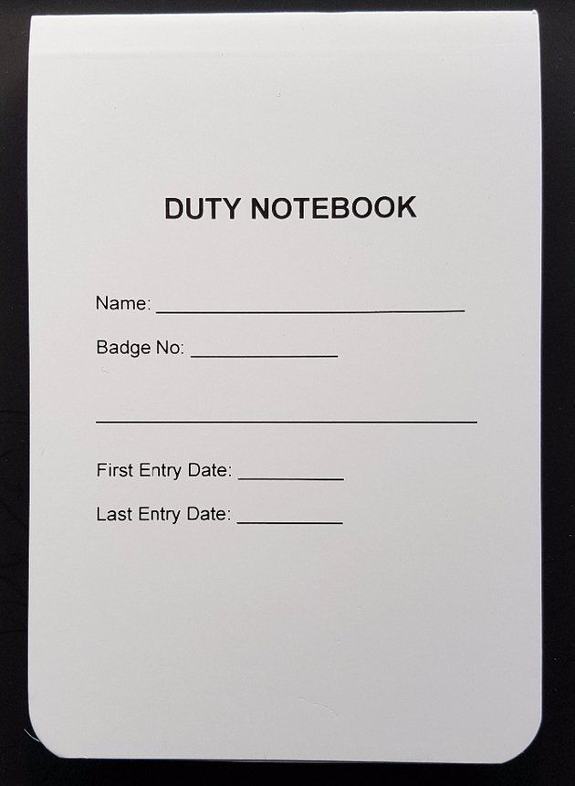 A white duty notebook is sitting on a black table.