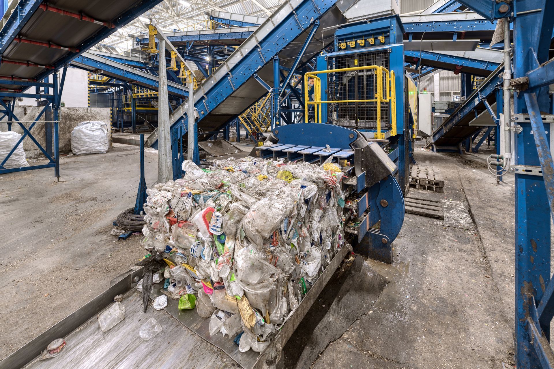 A conveyor belt is carrying a large pile of plastic bottles.