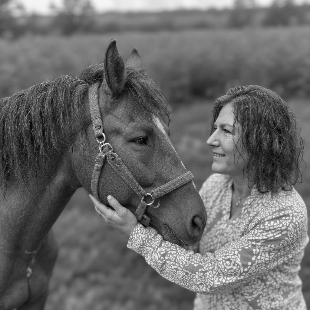 A woman is petting a brown horse in a black and white photo.