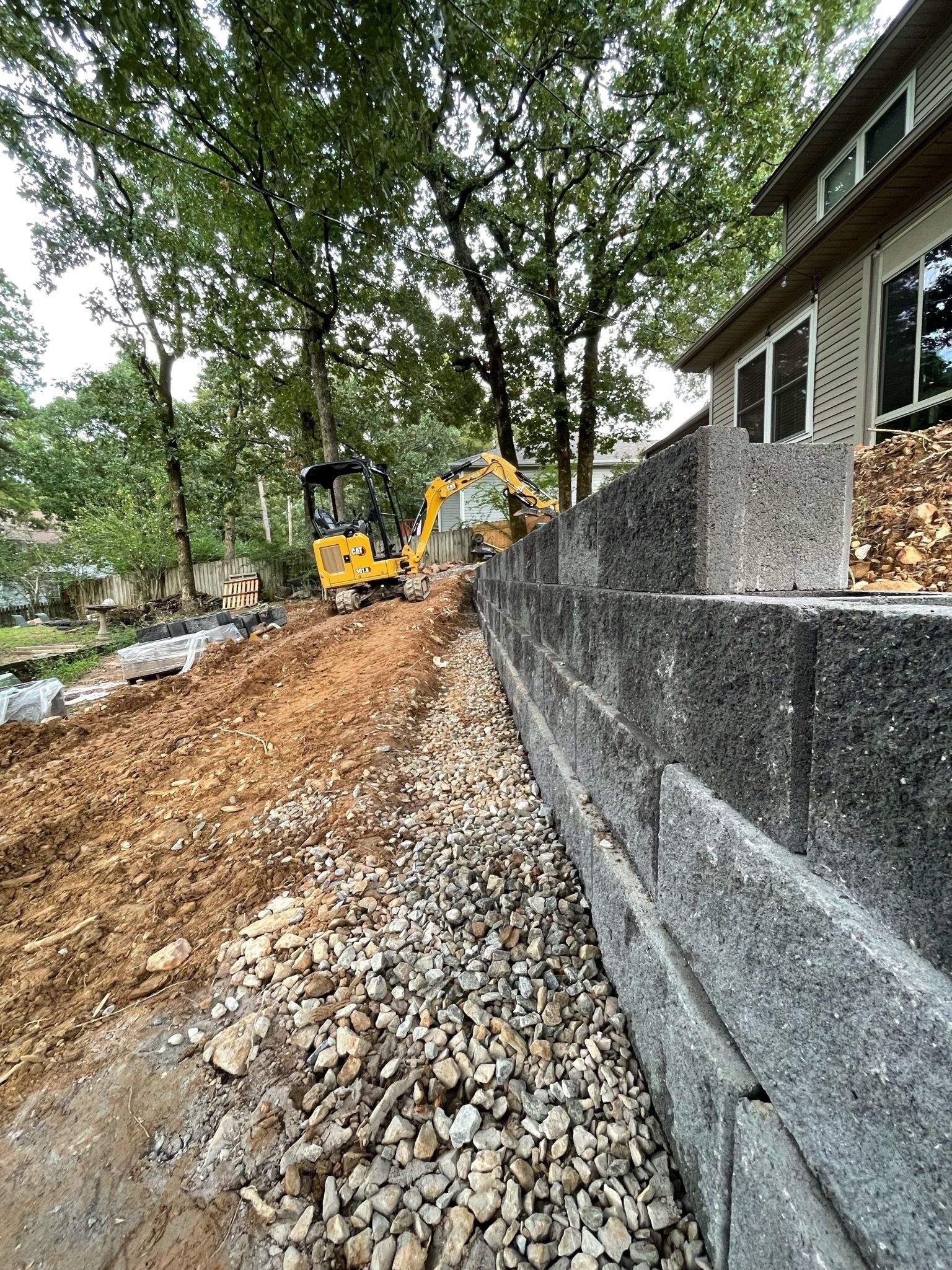 A brick wall is being built next to a house.