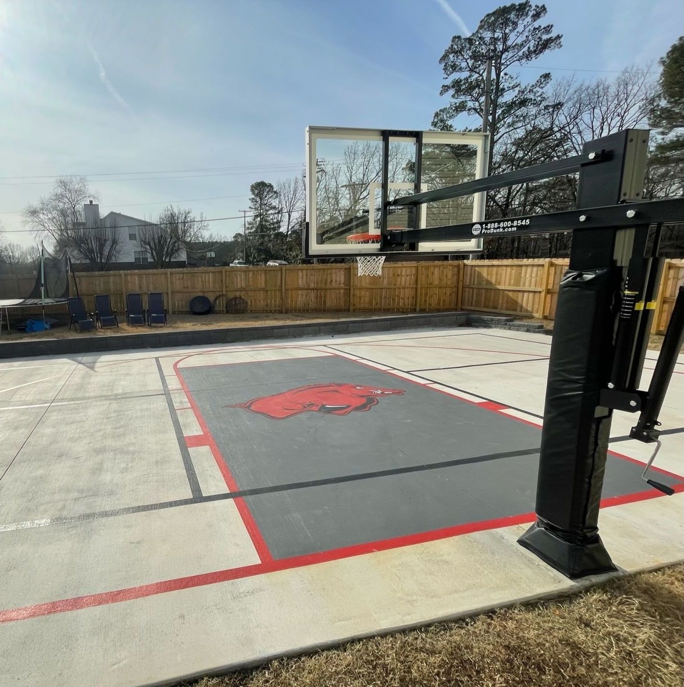 A basketball hoop is sitting on top of a concrete court.