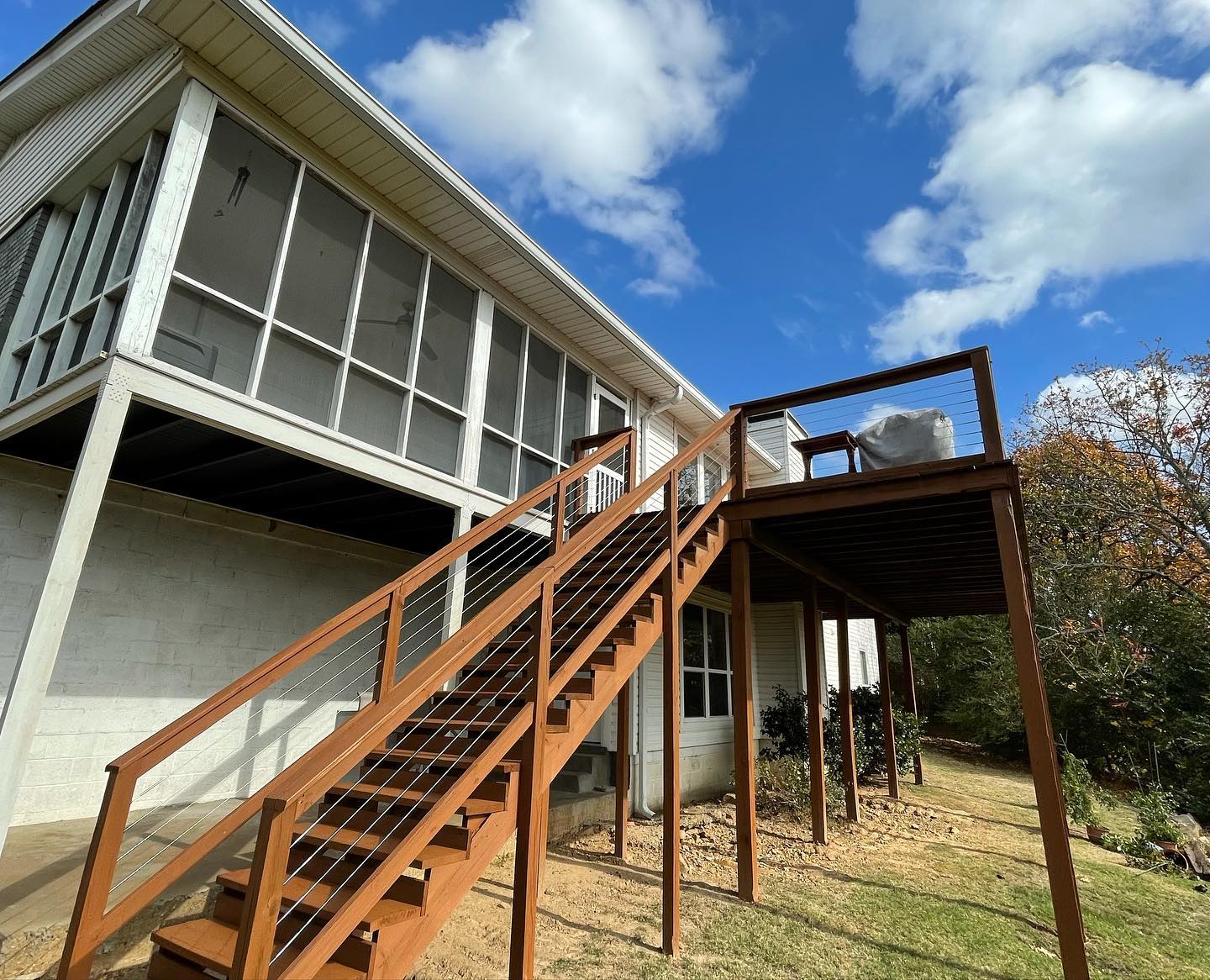A house with a screened in porch and stairs leading up to it