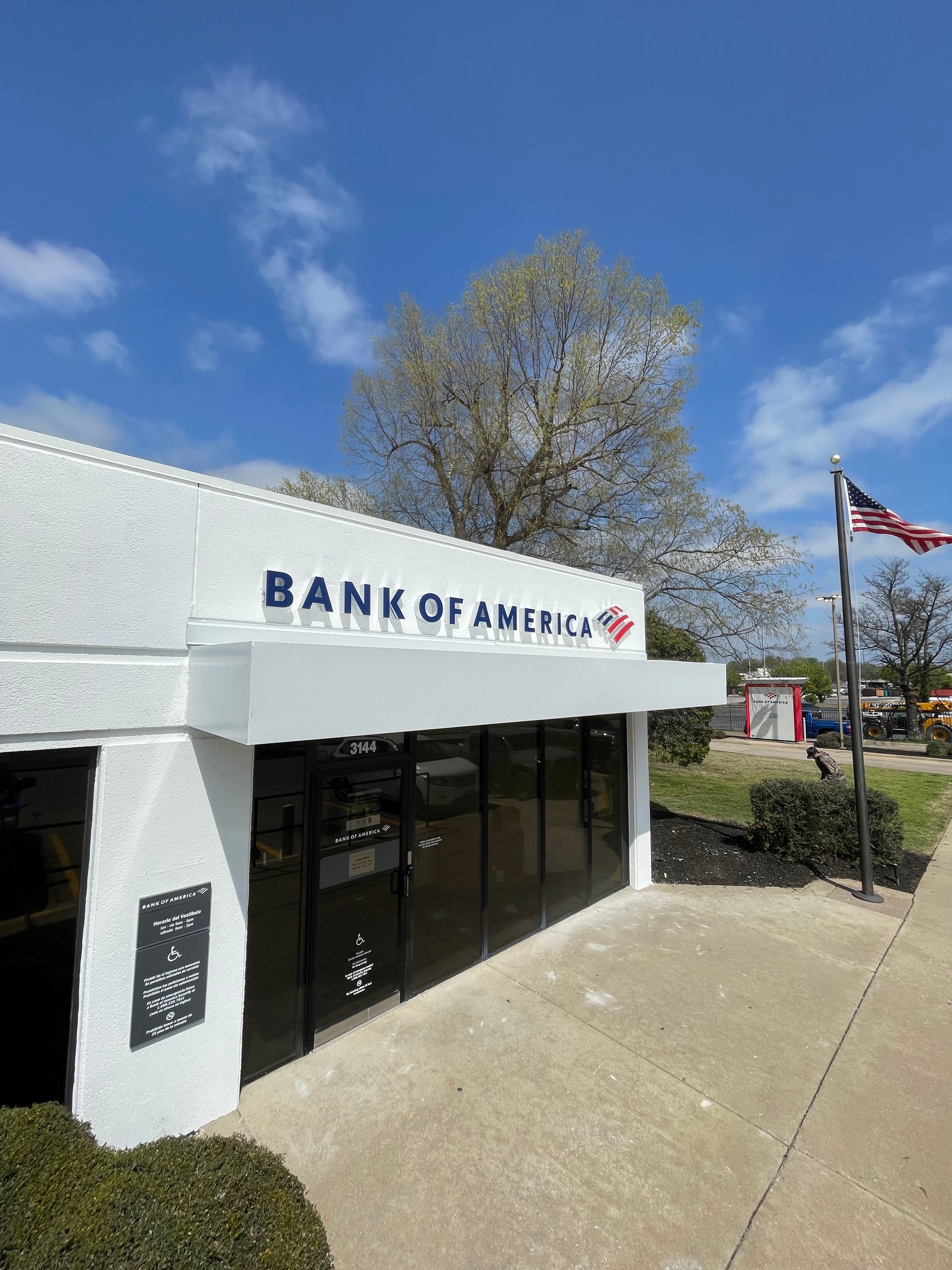 Bank of America building with a blue sky and American flag.