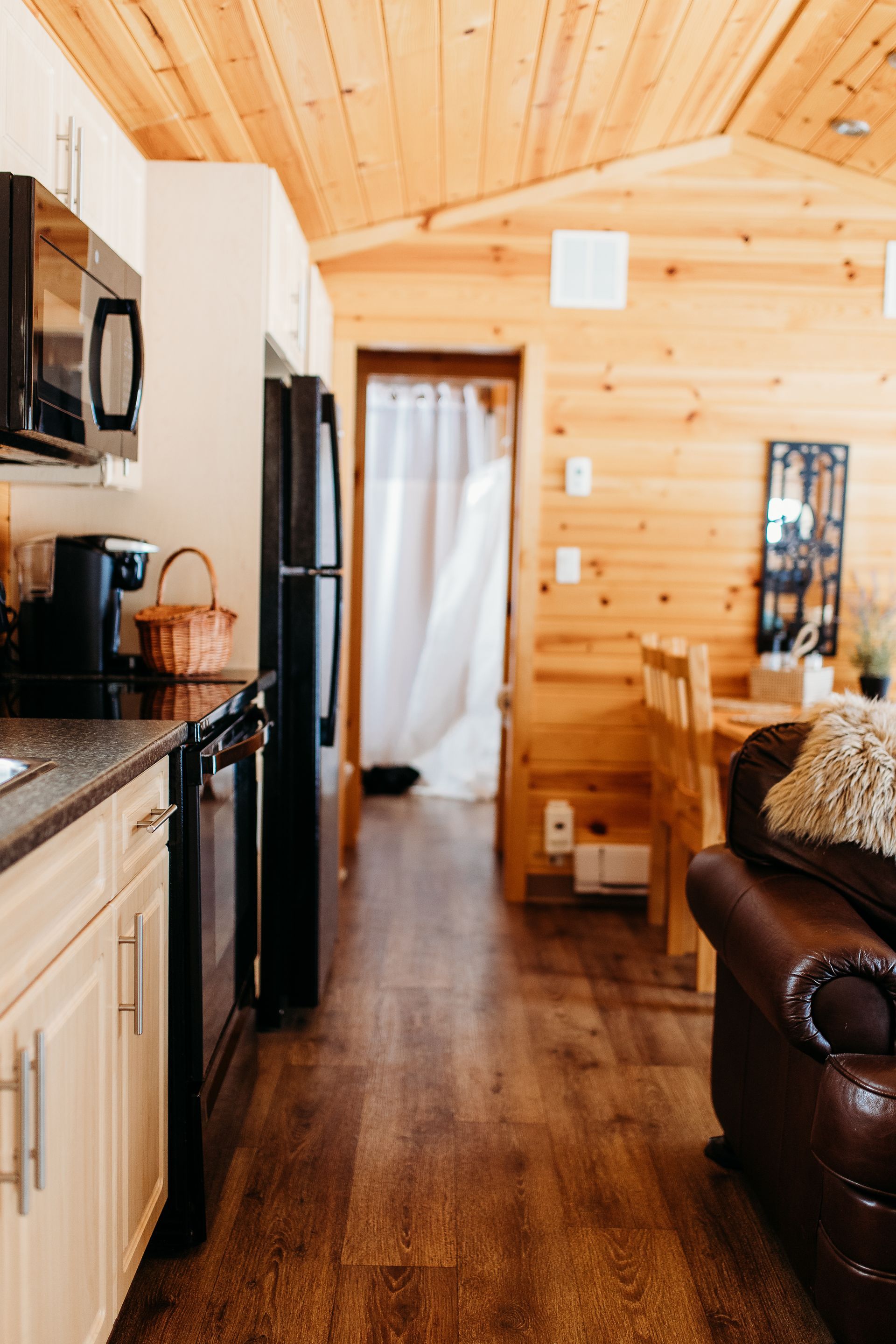 Kitchen with wood paneling, appliances, and a glimpse of a bedroom.