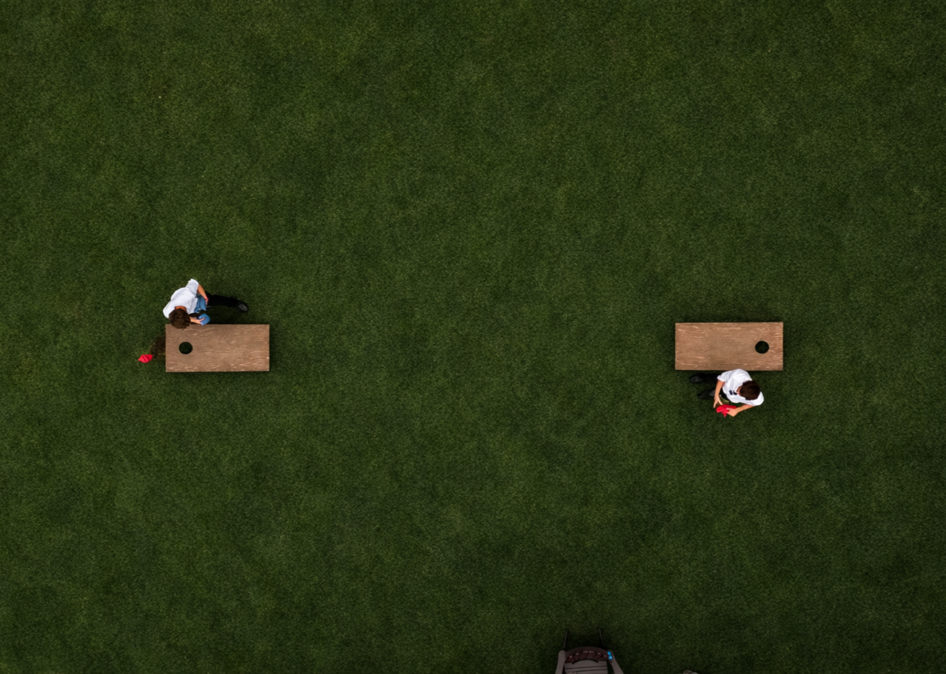 Guests play cornhole at whispering springs wedding