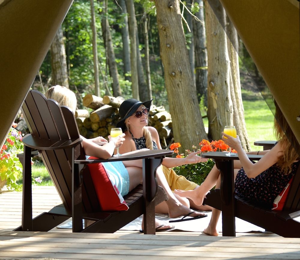 Colleagues gather outside glamping tent for a drink.