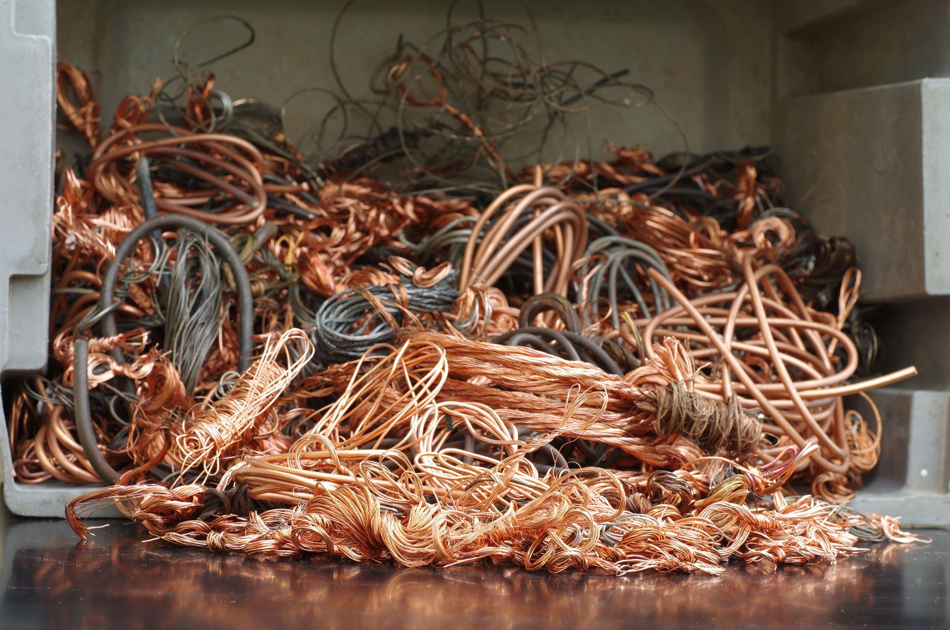 Pile of tangled copper and metal wires in a bin for ferrous metal recycling processing facility.