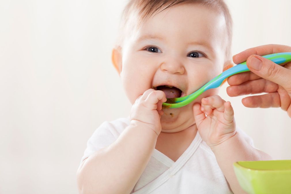 un bambino mangia con cucchiaio 