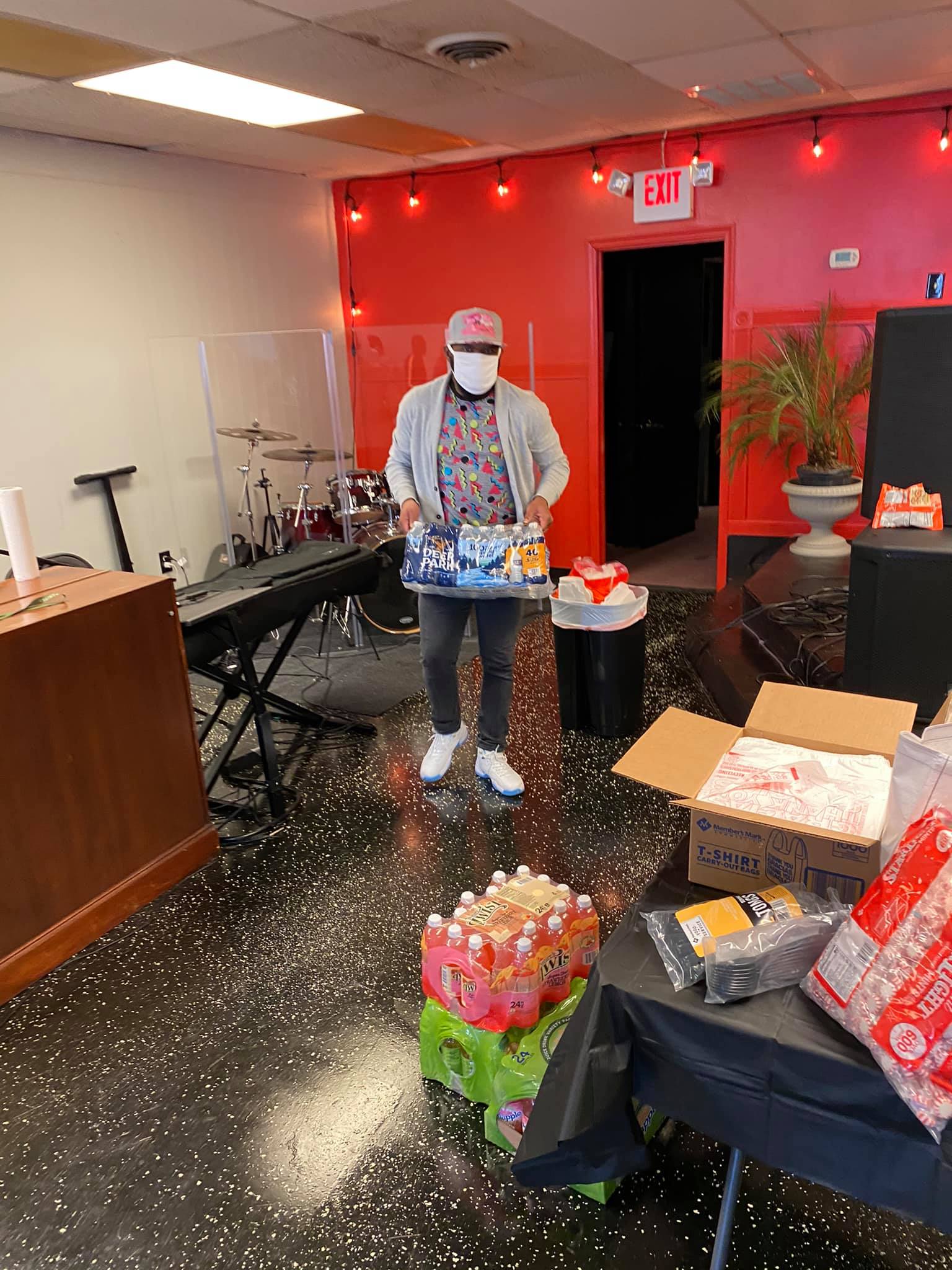 person carrying a case of water