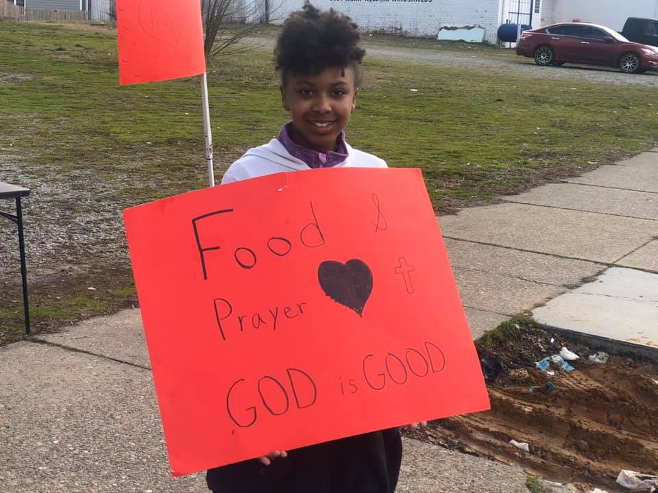 young lady standing with red sign
