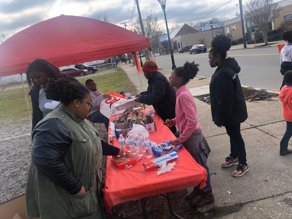 people at a red table giving donations