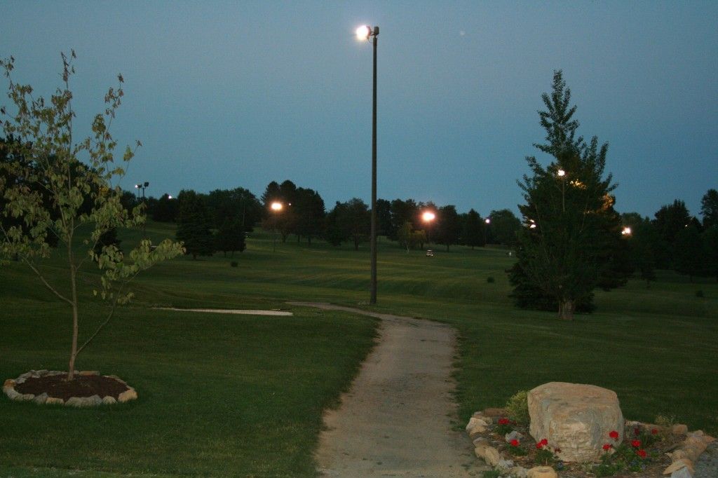 A path in a park at night with a street light