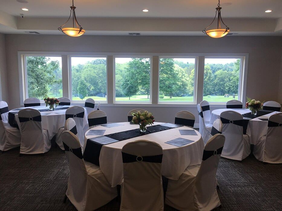 A room with tables and chairs set up for a wedding reception