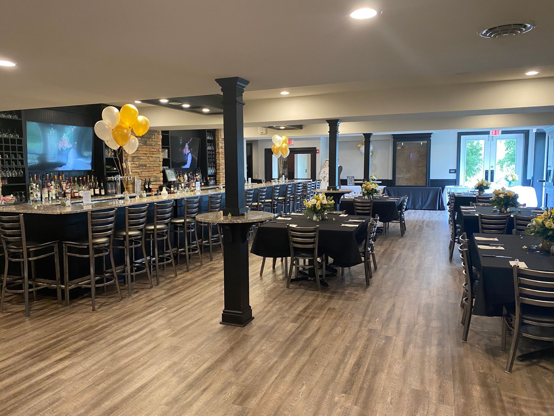 A large room with tables and chairs and a bar.