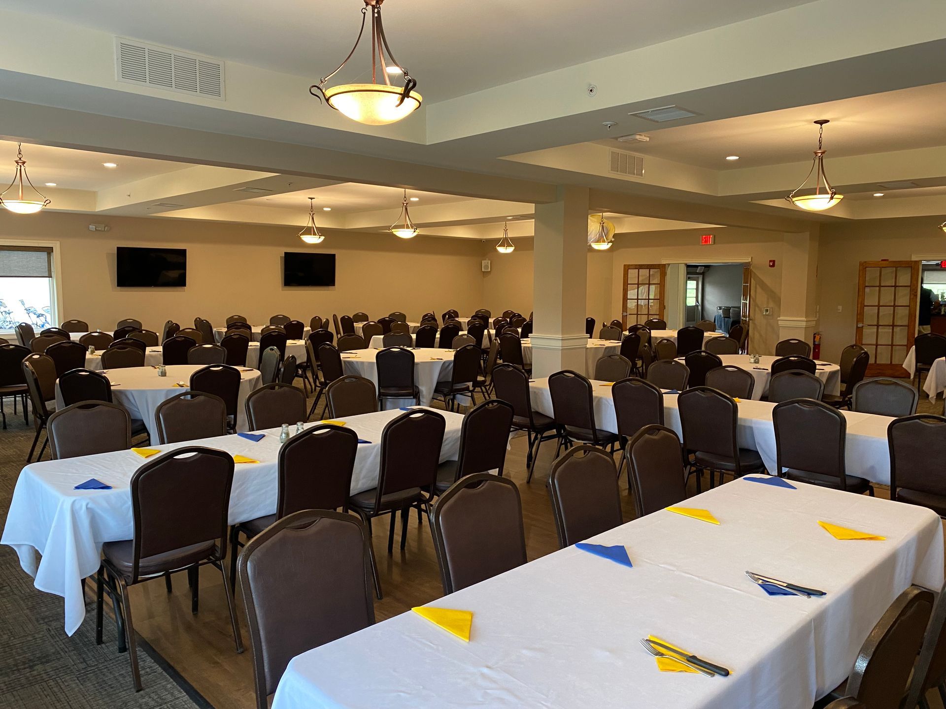 A large room with tables and chairs set up for a banquet.