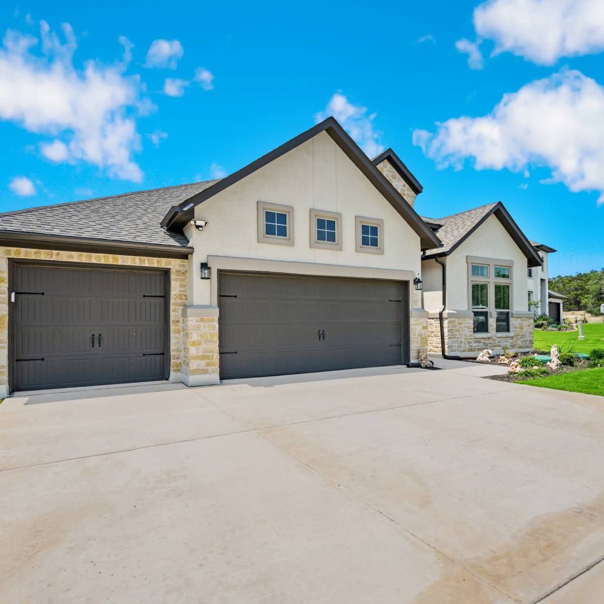 A large house with two garage doors on a sunny day