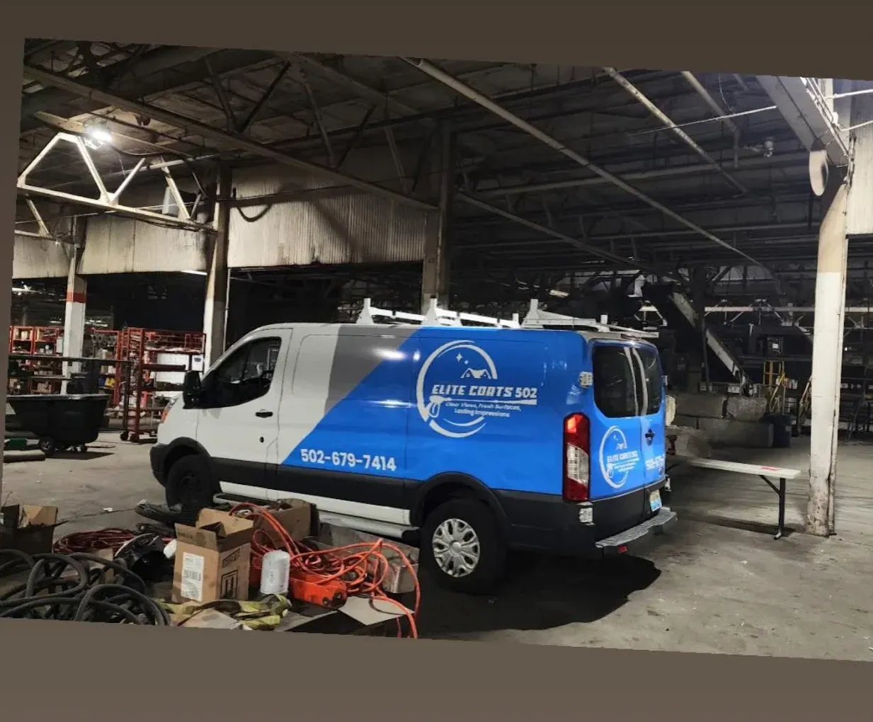 A blue and white van is parked in a warehouse.